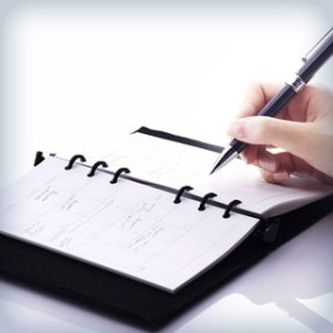 person writing in a datebook